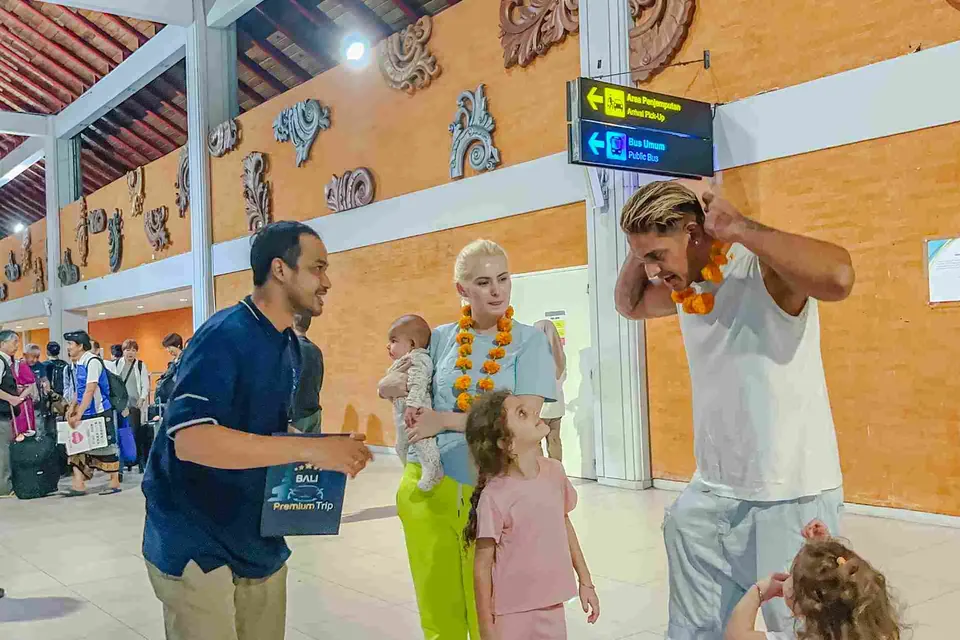 Bali Premium Trip driver welcoming a family in the Ngurah Rai arrivals hall