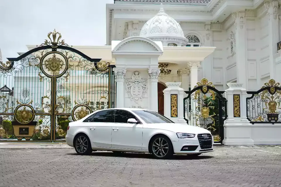 White Audi A4 sedan at a villa gate