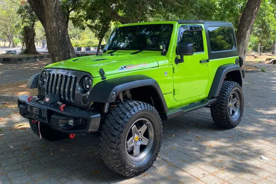 Neon green Jeep Rubicon Sahara parked under trees