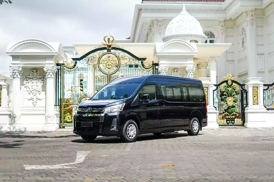 Black Toyota Hiace Premio Luxury van at a villa gate in Bali